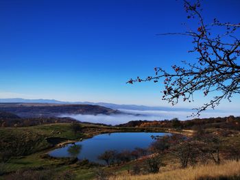 Scenic view of lake against clear blue sky