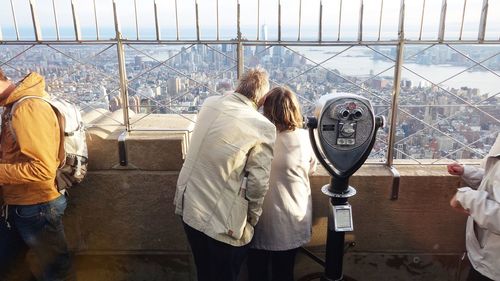 People at observation point against empire state building in city