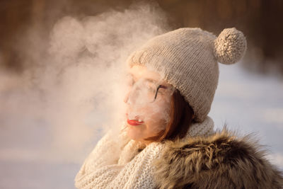 Close-up of young woman exhaling smoke