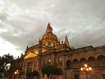 Low angle view of illuminated cathedral against cloudy sky