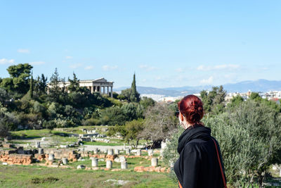 Woman visiting ancient civilization against sky