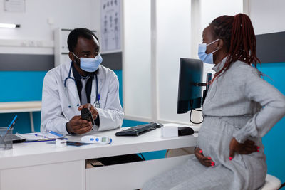 Female doctor examining patient in office