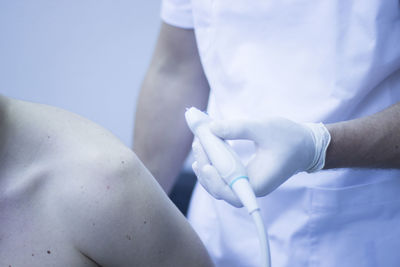 Close-up of doctor examining patient with medical equipment in hospital