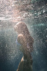Side view of woman swimming underwater