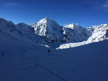 Scenic view of snowcapped mountains against blue sky