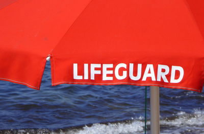 Information sign on shore against sea