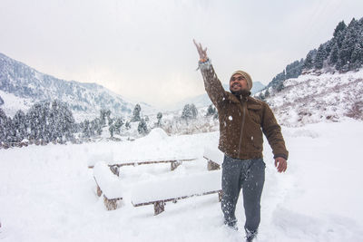 Full length of man standing on snow covered mountain