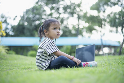 Portrait of young woman sitting on field