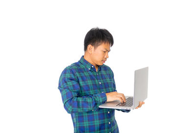 Mid adult man using smart phone against white background