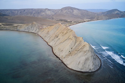 Spectacular drone view of hilly coastline of crimean peninsula with rough rocky cape washed by blue sea water