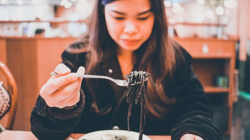 Midsection of woman holding ice cream in restaurant