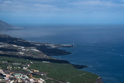 High angle view of townscape by sea against sky