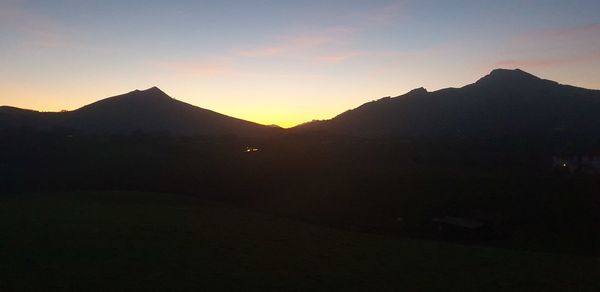 Scenic view of silhouette mountains against sky during sunset