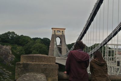 Rear view of couple on bridge against sky