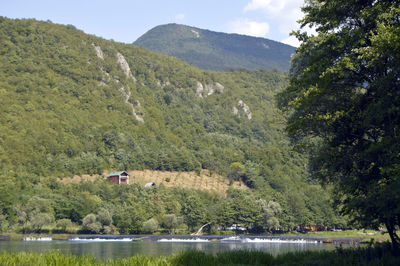 Scenic view of river and mountains against sky