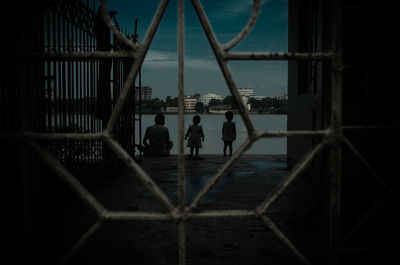 Children playing soccer on field against sky at night