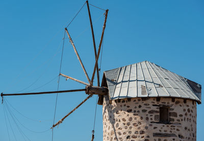 Low angle view of windmill against clear blue sky