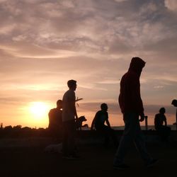 Silhouette of people against sky during sunset