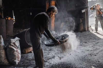 Photographer photographing worker in factory