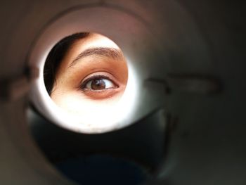 Close-up of woman looking through an object