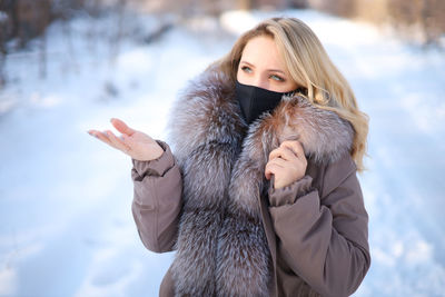 Woman wearing mask and warm clothing during winter