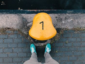 Low section of person standing by bollard on pier