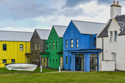 Colourful wooden house façades against cloudy  sky. 