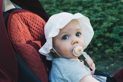 Portrait of cute baby girl siting in stroller