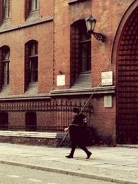 Full length of man walking by building in city