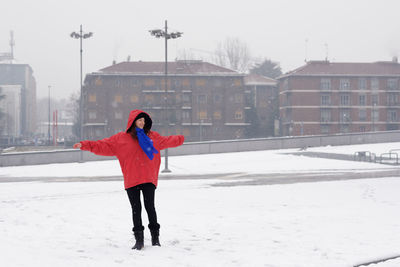 Full length of woman enjoying on snow covered field