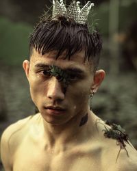 Close-up portrait of wet man wearing small crown