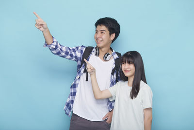 Young couple standing against blue background