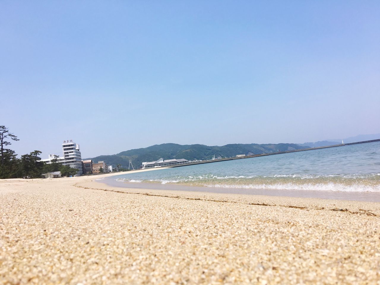 beach, sand, clear sky, shore, sea, copy space, water, tranquil scene, tranquility, blue, scenics, coastline, nature, beauty in nature, horizon over water, day, incidental people, outdoors, sunlight, idyllic