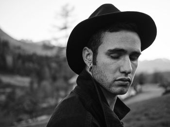 Portrait of young man looking away outdoors