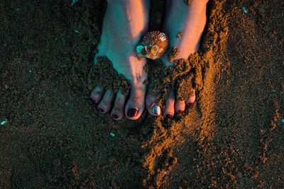 Low section of woman standing on sand at beach