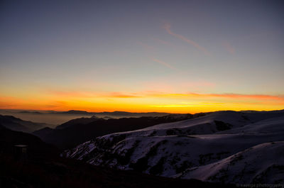 Scenic view of snowcapped mountains against sky during sunset