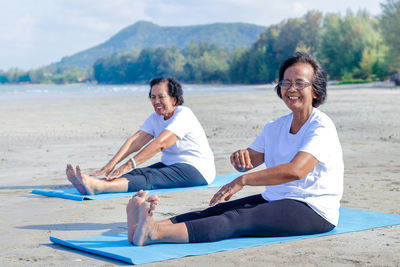 Smiling senior woman exercising at beach