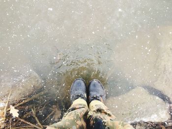 Low section of person standing in water