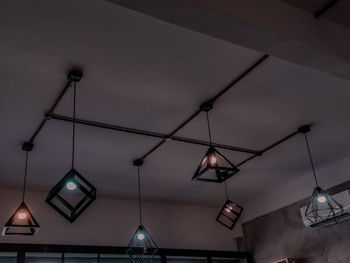 Low angle view of illuminated pendant lights hanging from ceiling