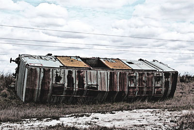 Old ruin on field against cloudy sky