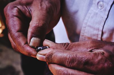 Close-up of man holding coffee bean