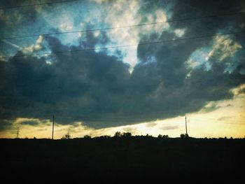 Silhouette of landscape against cloudy sky