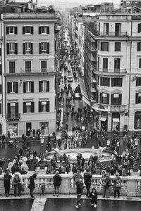 People on street against buildings in city