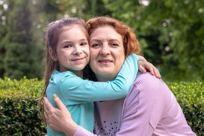 Portrait of a happy woman and daughter smiling and looking at the camera.