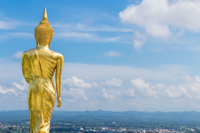 Statue of buddha against cloudy sky