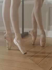 Low section of woman standing on hardwood floor