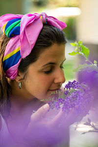 Young woman smelling violets flowers