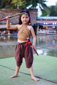 Full length portrait of girl standing outdoors