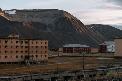 Houses by buildings against sky