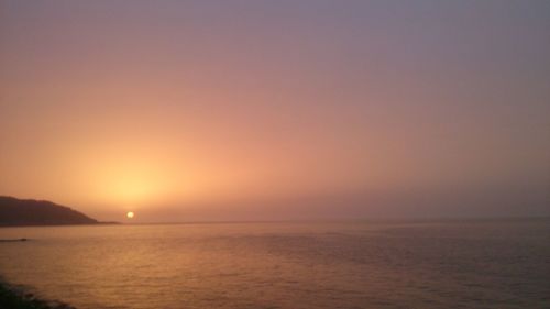 Scenic view of sea against orange sky